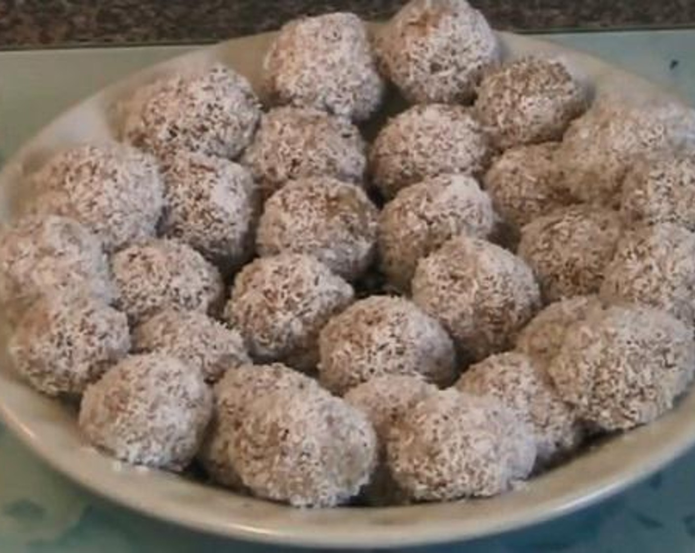 step 2 Then add in the Sweetened Condensed Milk (1 1/4 cups) and combine everything well. When serving, take small ball shapes of the mixture and roll them over the Desiccated Coconut (as needed) until they are covered well. Serve and Enjoy!