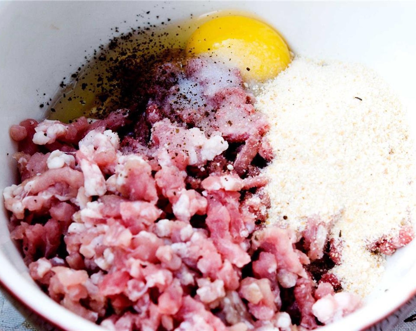 step 2 Combine Ground Pork (9 oz), Salt (1 pinch), Ground Black Pepper (1 pinch), Ground Nutmeg (1 pinch), Egg (1), Breadcrumbs (3/4 cup), and the onion in a bowl.