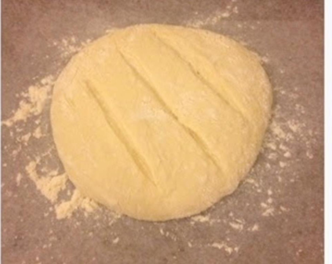 step 4 Transfer onto a floured surface, and gently fold the corner of the dough into the middle. Form a round smooth dough. Line a tray with parchment paper with flour on it. Transfer the dough onto it. Let the dough rise for an hour.