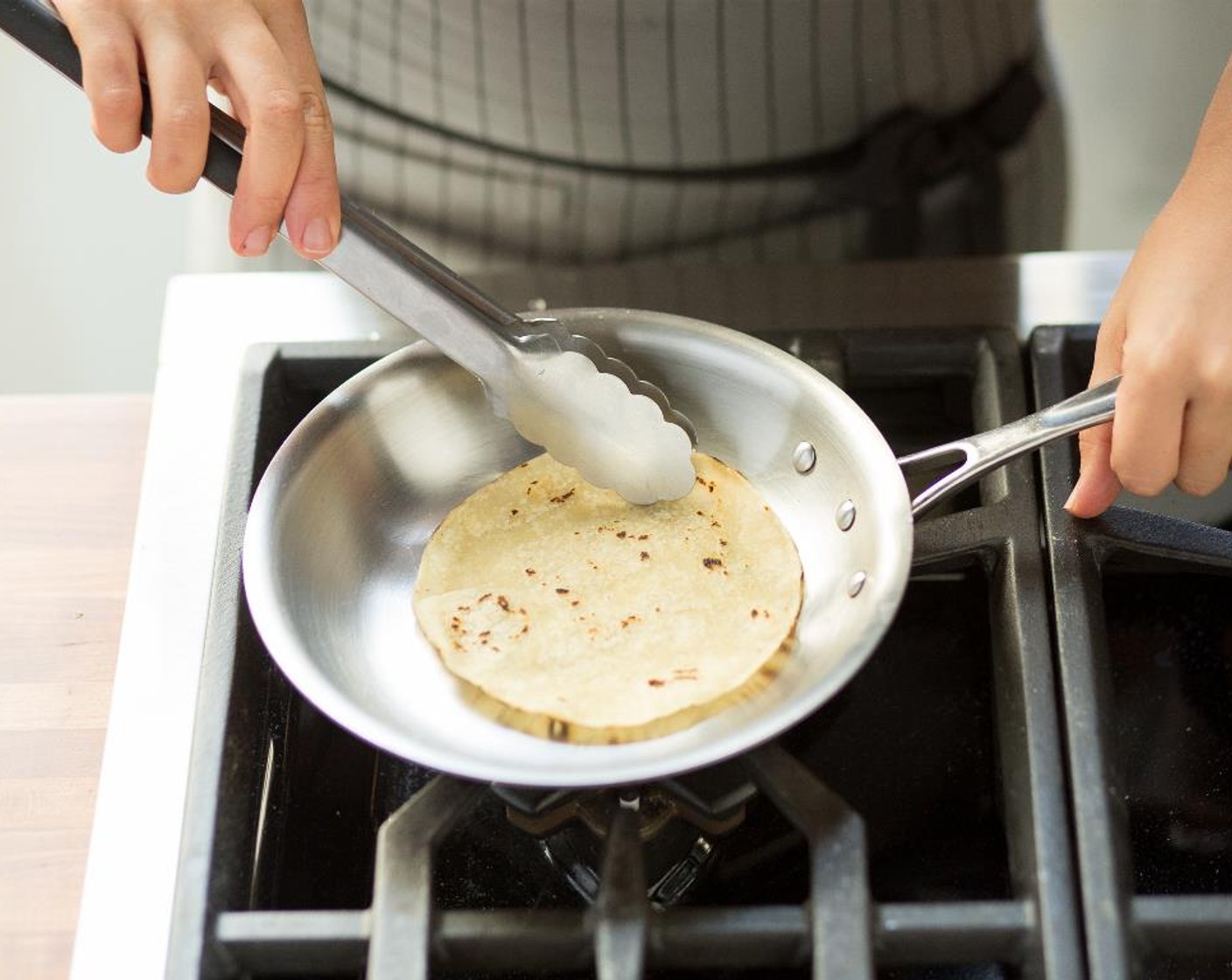 step 8 Heat a small sauté pan over medium-high heat. Add the White Corn Tortillas (4) one by one, and heat until very hot. Keep warm for plating.