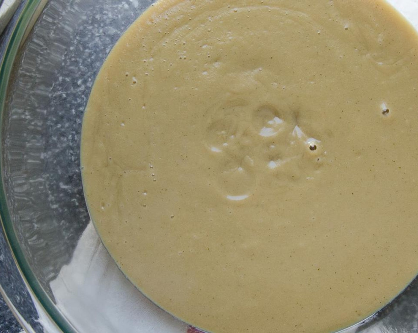 step 5 Remove the custard from the heat and pour through a strainer into a large clean bowl - to remove any egg solids.