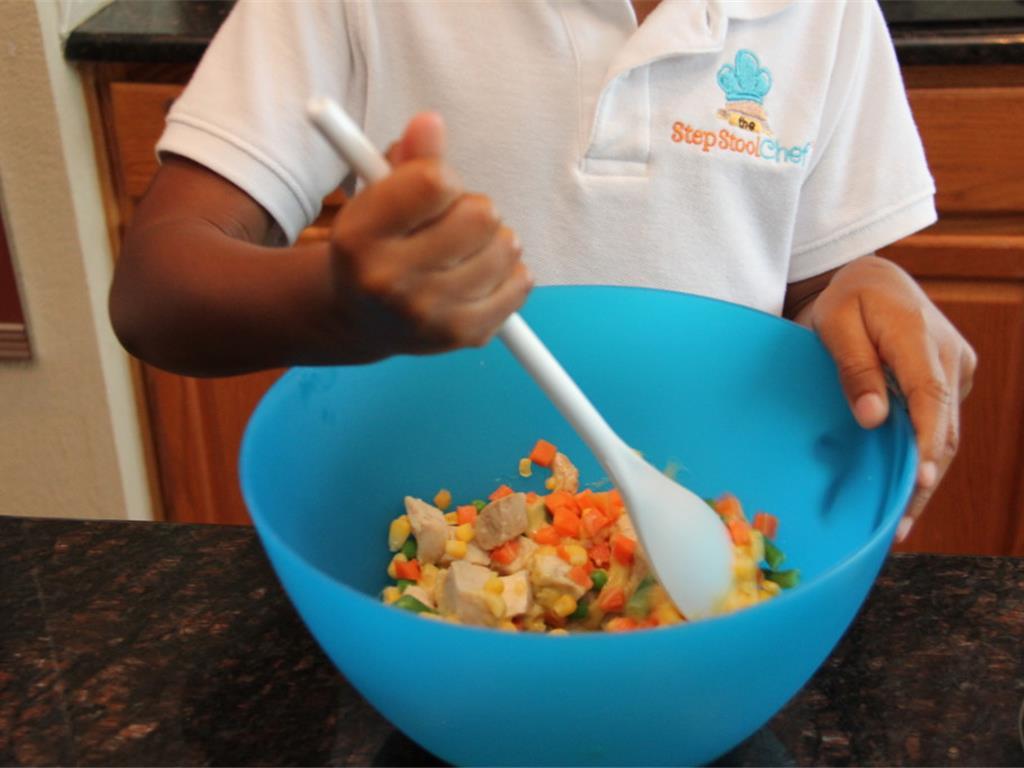 Step 2 of Muffin Tin Pot Pie Recipe: Mix Cream of Chicken Soup (1 1/2 cup), Ground Black Pepper (to taste), and Chicken (1 cup) in a bowl. Add Salt (to taste) and Mixed Vegetables (1 cup).