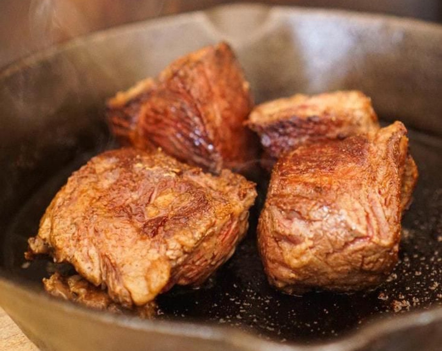 step 3 Heat the Canola Oil (2 Tbsp) over medium high heat in a large cast iron skillet. Once hot, sear the short ribs on all sides until browned and caramelized. Do this in batches if necessary. This should take a total of 10-15 minutes.