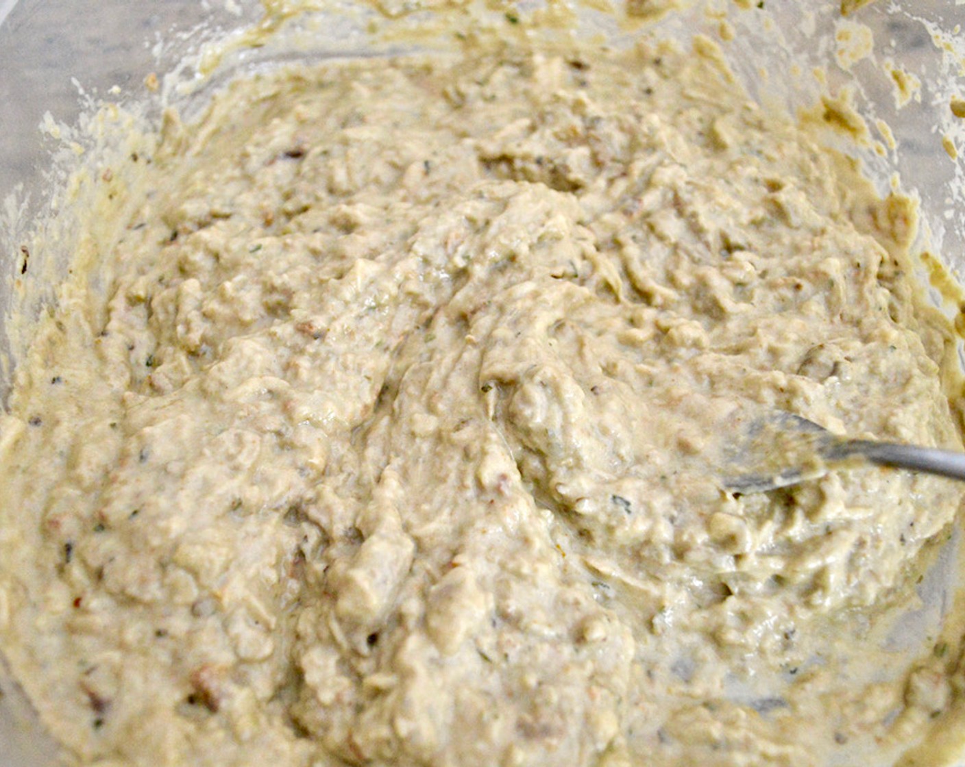 step 6 Stir in the Lemon Juice (1), Tahini (4 Tbsp), and Garlic (5 cloves). Mash with a fork until everything comes together. Then, slowly pour in Olive Oil (1/3 cup), keep stirring until it’s incorporated into a creamy mixture.
