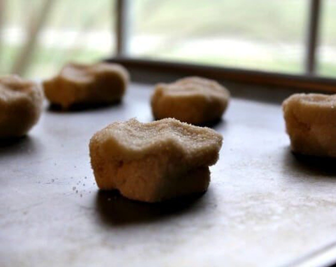 step 8 Pour Granulated Sugar (4 Tbsp) into a small shallow bowl. Roll cookie dough into balls. The smaller the amount, the smaller your sandwiches will be. We rolled ours into approximately 1 1/2 inch sized balls. Roll each cookie dough ball into the sugar. Place on a baking sheet 2 inches apart. Gently press the tops to flatten slightly.