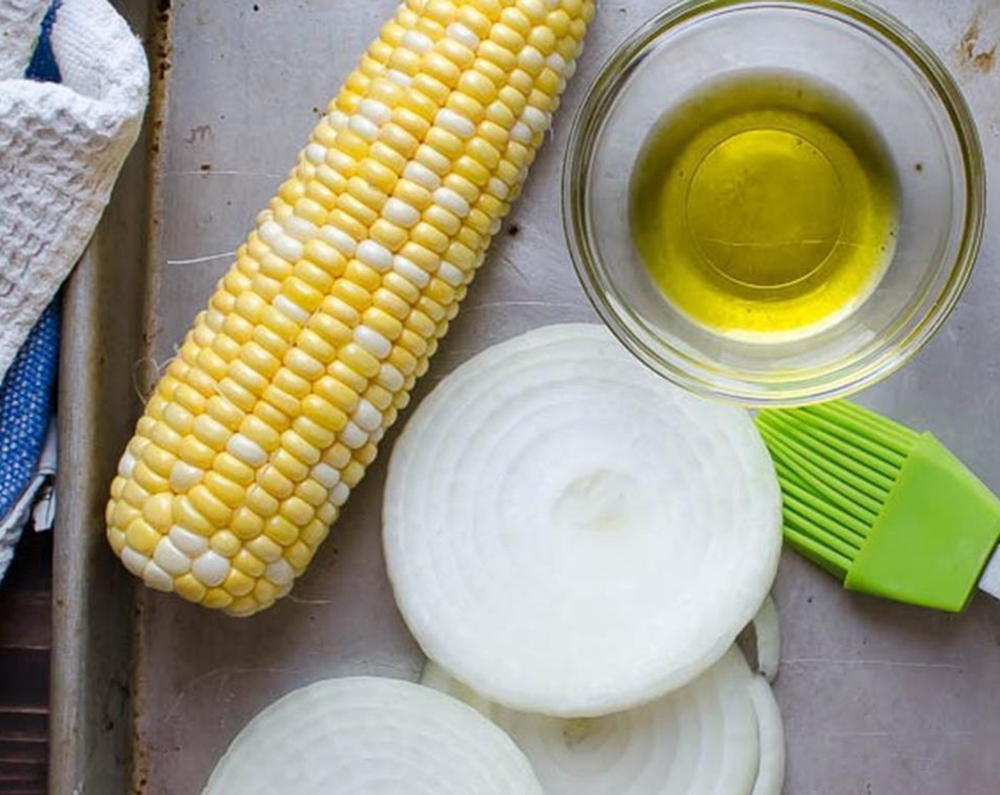 step 1 Slice the Sweet Onion (1) into quarter-inch rounds and place on a baking sheet. Shuck the Corn (1 ear) and place it on the sheet. Brush the onions and corn with Olive Oil (1 Tbsp), just so it's lightly coated.