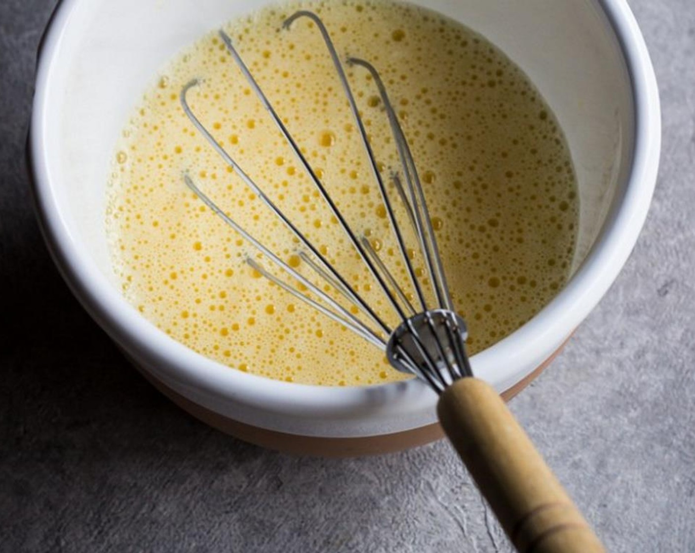 step 4 While whisking, slowly add one ladle of the soup at a time to the egg and lemon mixture to temper the mixture.