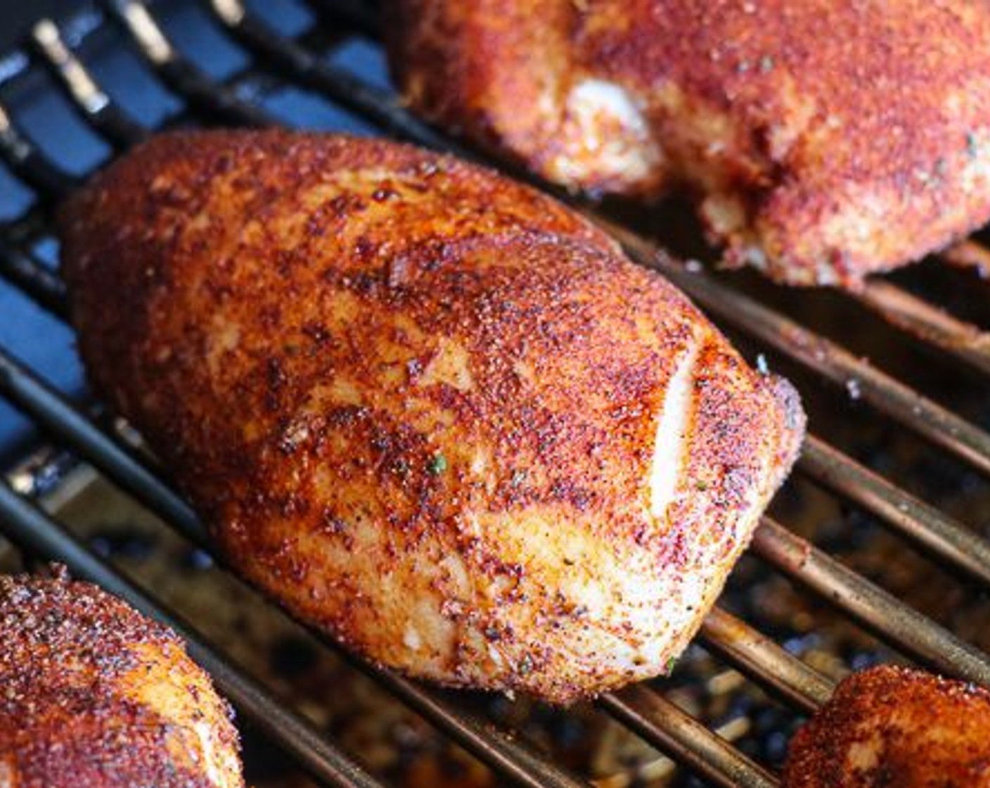 step 3 Place the breasts on the pellet grill, insert a probe thermometer to monitor internal temperature.