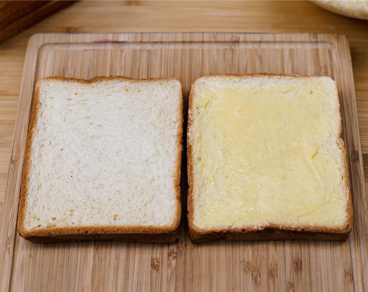 step 4 Generously spread one side of the bread with Salted Butter (1/4 cup) and flip over.