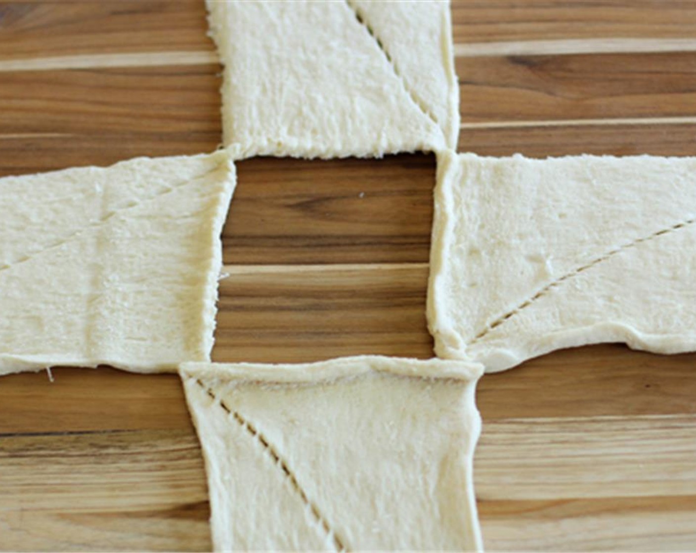 step 4 Take the Crescent Roll Dough (1 can) and separate dough into 4 rectangles (2 crescents per section). Place on cookie sheet in a circular shape resembling a compass.