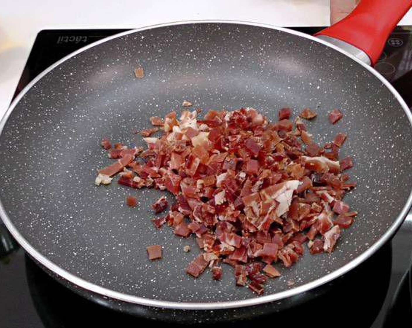 step 2 Quickly fry the finely chopped serrano ham in a hot pan with a little bit of olive oil.