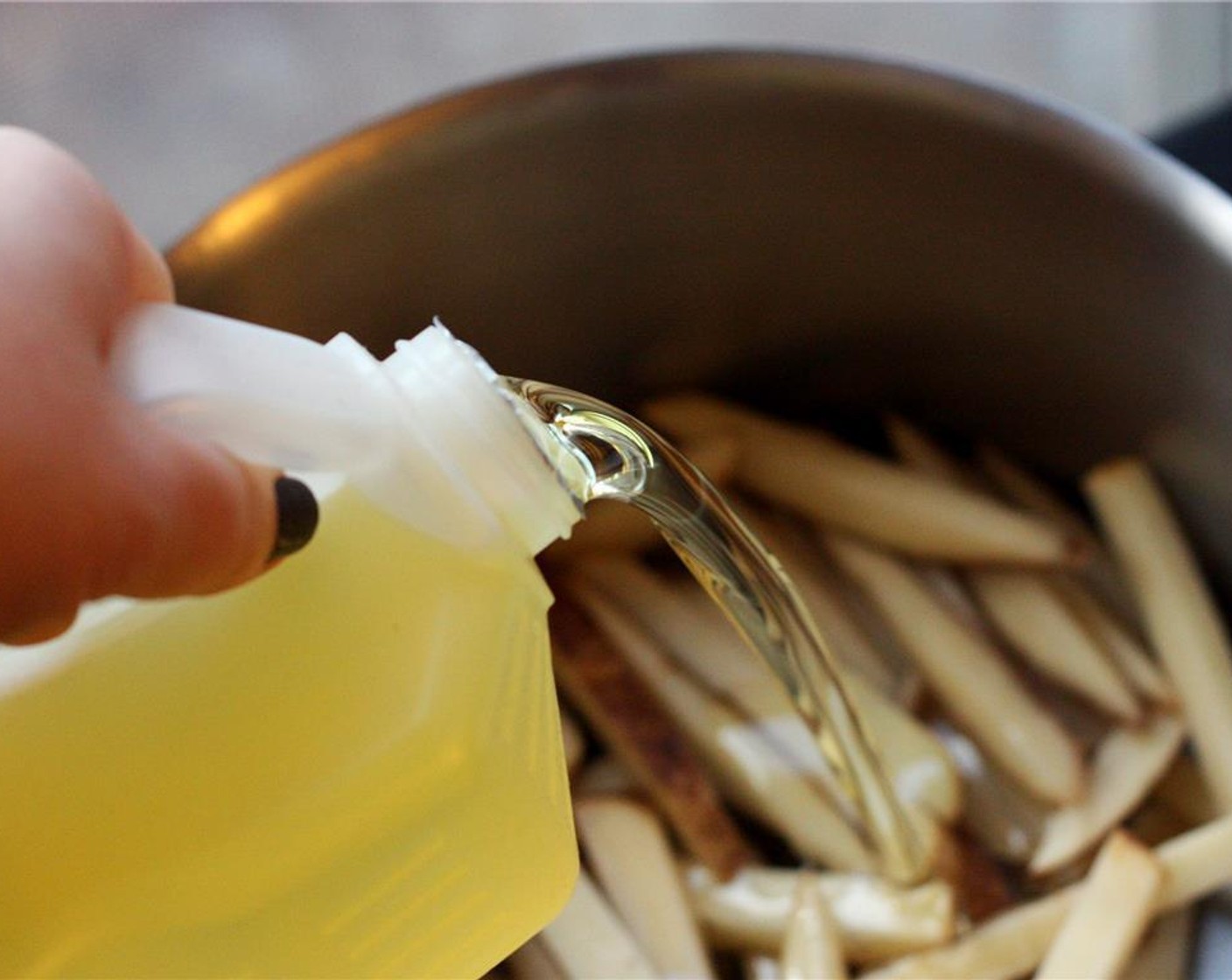 step 4 Spread the strips evenly in the bottom of a large, wide-bottomed pot or Dutch oven, stacking them no more than two or three deep. Pour the Vegetable Oil (as needed) over the strips until they are covered by about an inch.