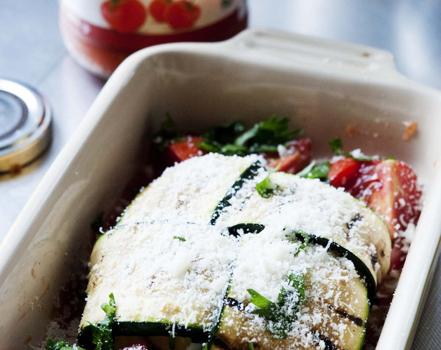 step 8 Halve some Cherry Tomato (1 cup) and place them next to the zucchini pocket. Sprinkle some Parmesan Cheese (to taste), add some Fresh Basil (to taste). Drizzle some Extra-Virgin Olive Oil (as needed) on top.