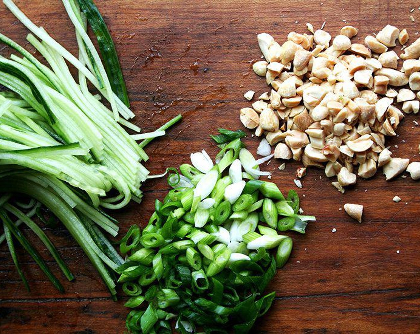 step 4 Let the noodles dry in a colander, and, if need be, gently pat them dry with some paper towels. Meanwhile, julienne the Cucumbers (3) on a mandoline or slice them into slivers with a knife. Chop Scallion (1 bunch) thinly on the bias. Coarsely chop the Dry Roasted, Unsalted Peanuts (1/2 cup).