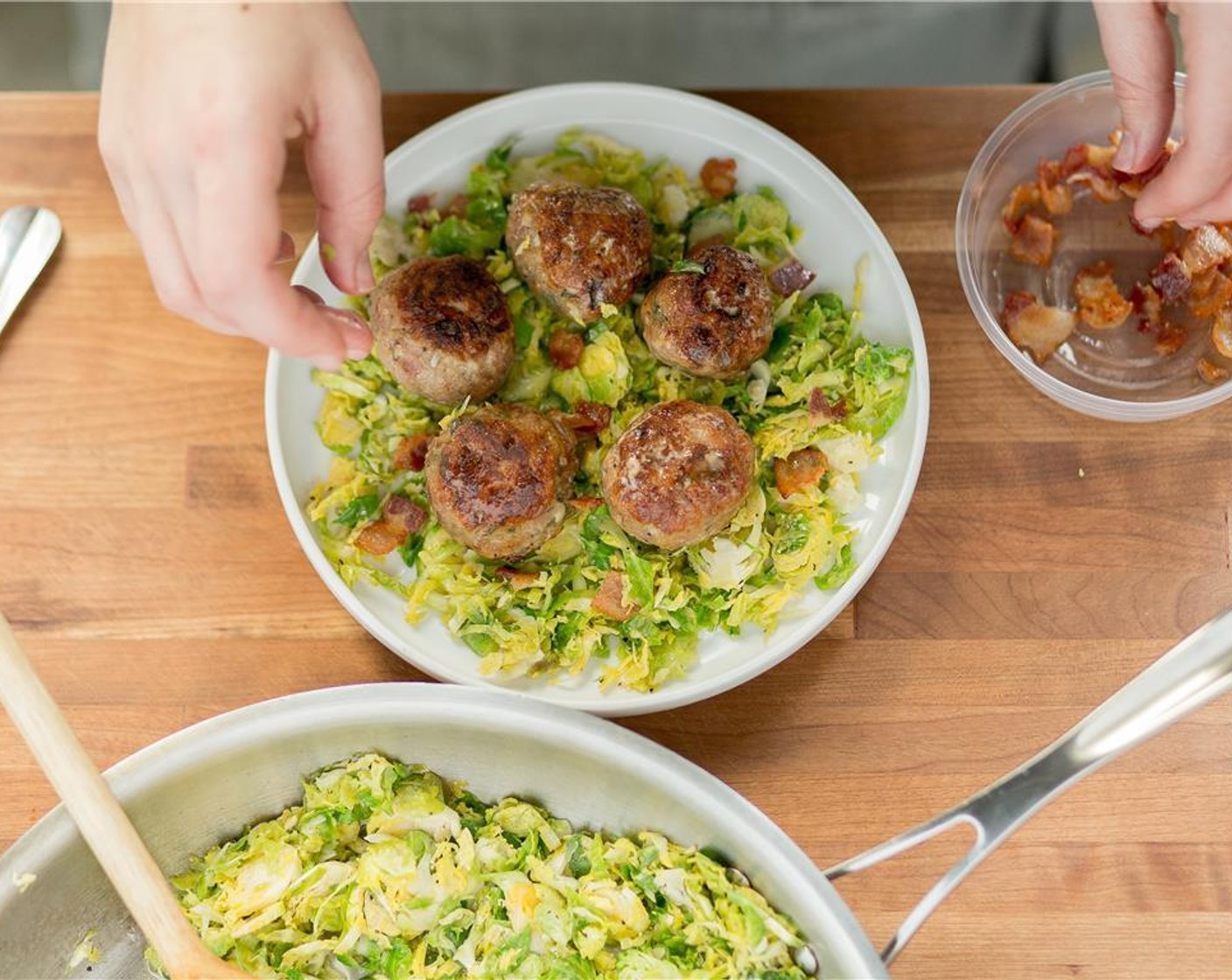 step 13 Toss the cooked bacon with the Brussels sprouts. Divide the Brussels sprouts between two plates at top center of plate. Divide the meatballs and plate alongside the front of Brussels sprouts. Drizzle sauce over each meatball for both plates.