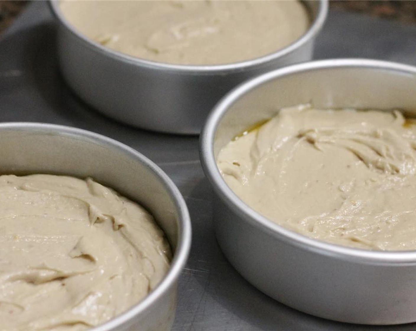 step 6 Pour batter into three 6-inch greased baking pans. Bake at 350 degrees F (180 degrees C) for approximately 1 hour.