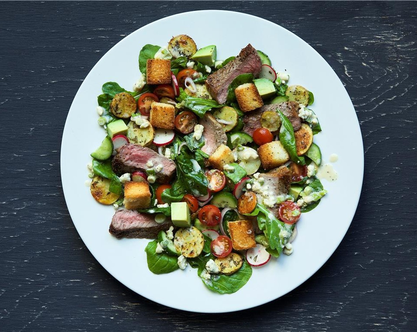 step 13 Place sliced steak on each plate fanned out in front leaning on the salad. Drizzle remaining dressing over the stead from end to end.