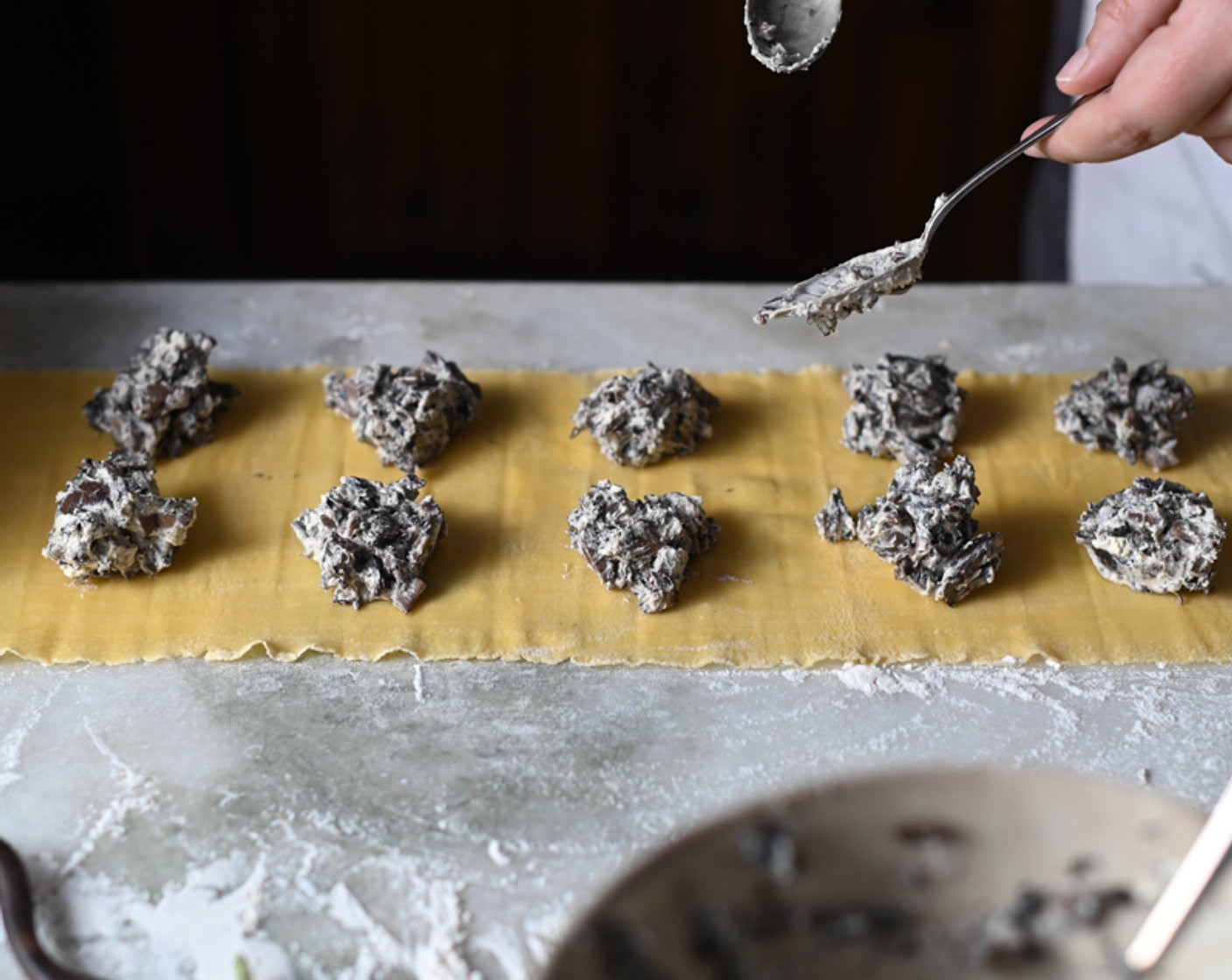 step 10 Spoon the chilled ricotta mixture along the pasta sheet, working in 10-milliliter dollops spaced equidistantly to allow for an edge.