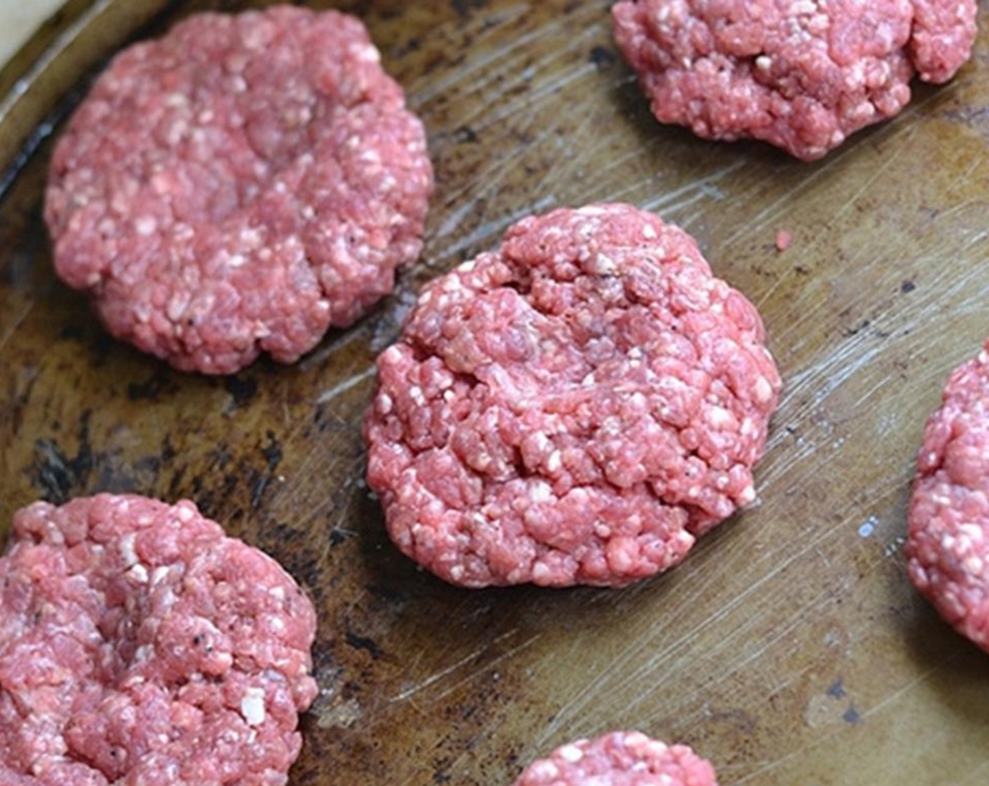 step 3 Form beef into loosely packed patties. Gently pat each handful into a ball and make a dent in the middle of each burger patty.