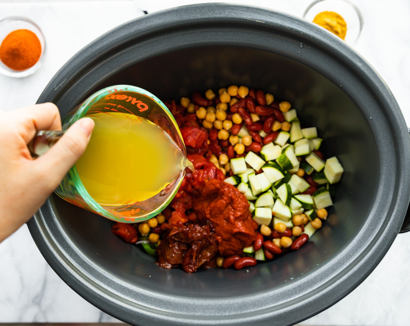 step 2 Add the Chili Powder (2 Tbsp), Ground Cumin (1 Tbsp), Chickpeas (1 can), Red Kidney Beans (1 can), Fire Roasted Diced Tomatoes (1 can), Vegetable Broth (2/3 cup), Zucchini (1/2 cup), Chipotle Peppers in Adobo Sauce (3 Tbsp), and Tomato Paste (1/4 cup) to the slow cooker. Cook on high for 90 minutes or low for 3 hours.