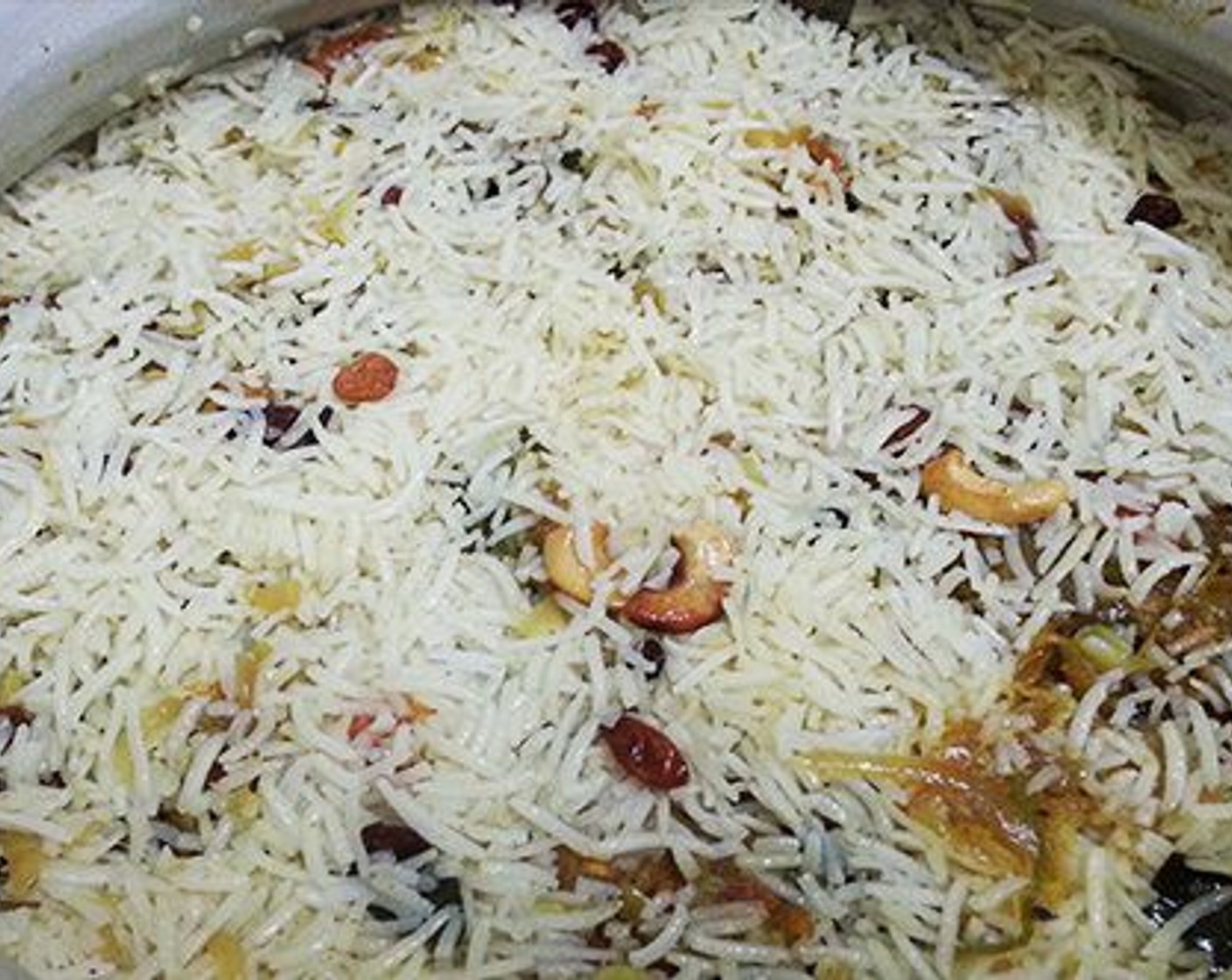 step 13 Take a heavy bottom flat vessel/biriyani pot and add a little ghee, spreading it to all sides. Take half of the rice and spread it well.
