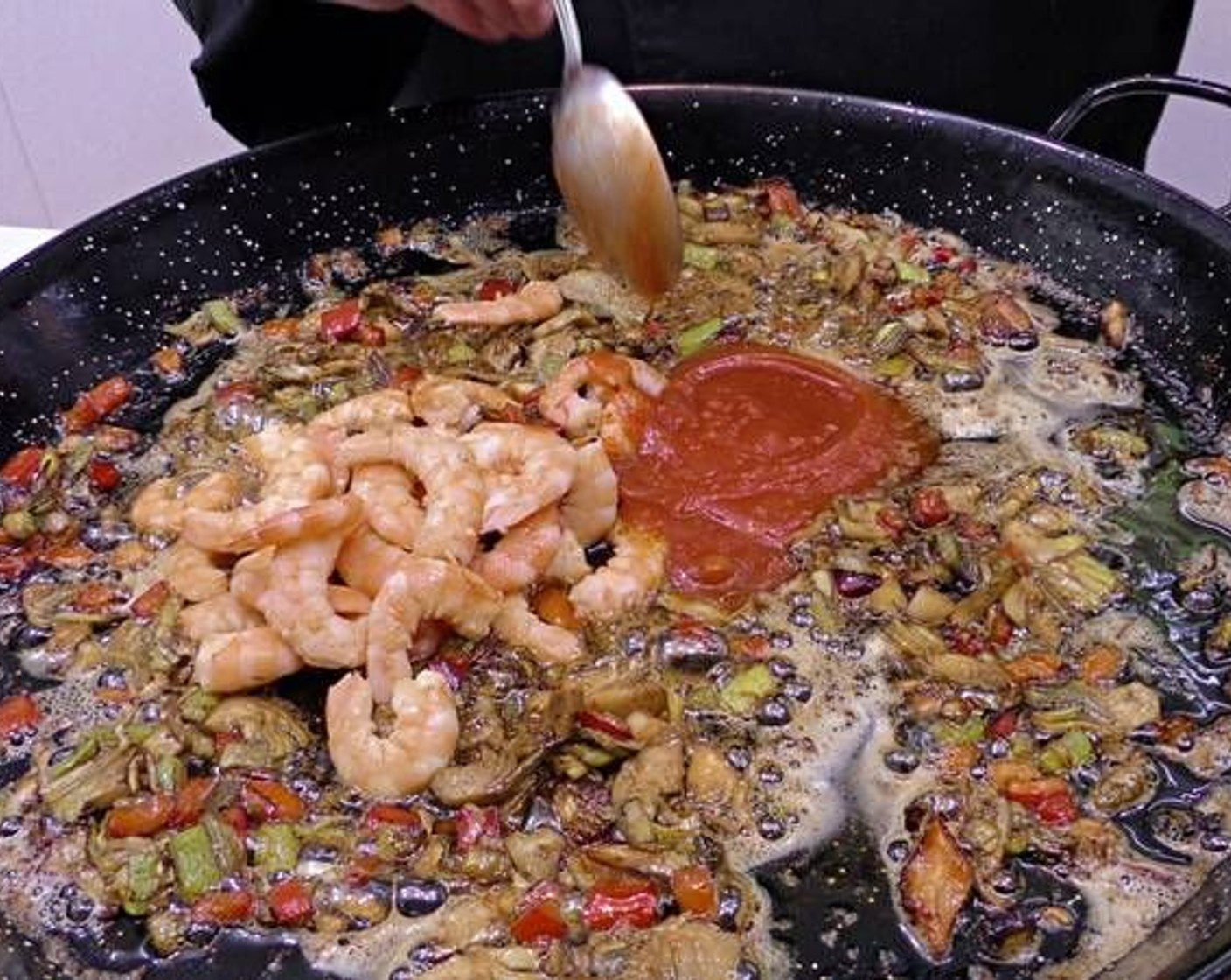 step 5 Once the langostino's are cooked, remove and peel to add back in. Add in the Canned Tomato Purée (3 Tbsp) and cook until dissolved.