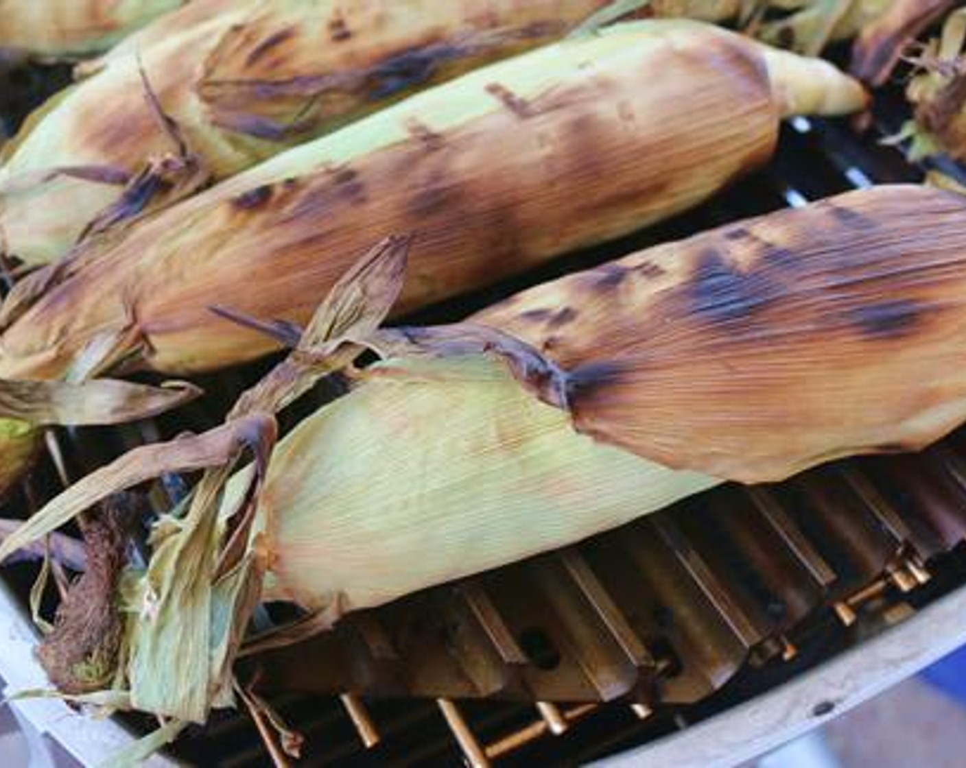 step 3 Peel back the husk and remove corn silt. Place directly over hot side of grill to char, 4-5 minutes rotating as necessary.