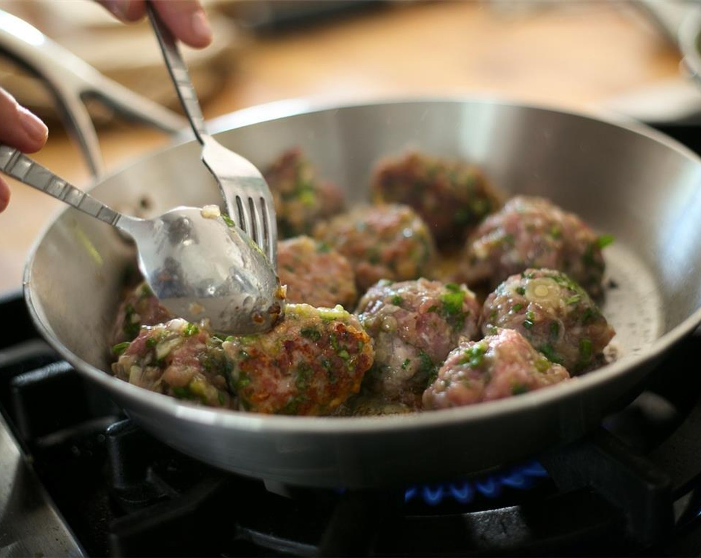step 12 Heat a medium saute pan with an oven proof handle over medium high heat. Add one tablespoon of oil and sear the meatballs on two sides for three minutes each side. Be sure not to burn them.