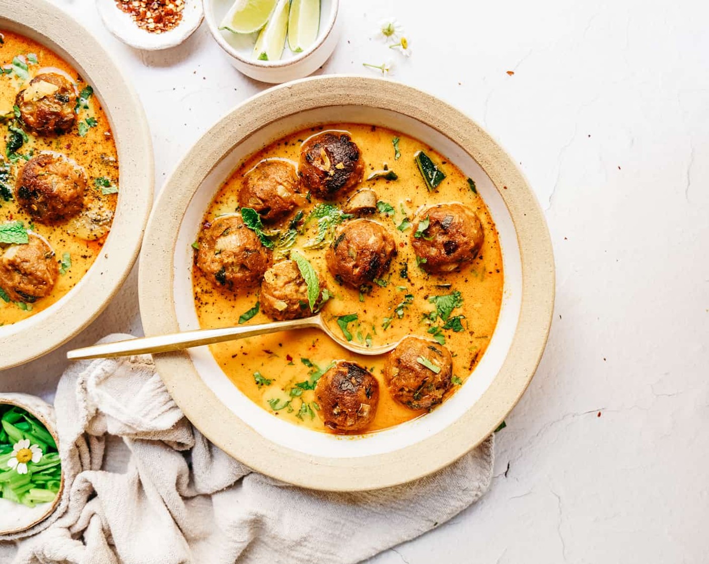 step 7 To assemble, place a generous amount of soup base in a bowl, add in some meatballs and rice/grain/pasta, and top with rice and Fresh Cilantro (to taste), Fresh Mint (to taste), Limes (to taste), and Crushed Red Pepper Flakes (to taste).