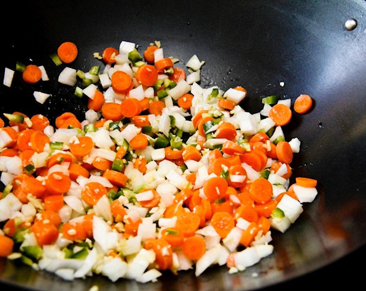 step 7 In a large pan or wok, heat peanut or Vegetable Oil (as needed).  Don’t use olive oil because it doesn’t hold up well to high heat. Add the onions, carrot, jalapeño, garlic, and ginger. Sauté until nice and soft.