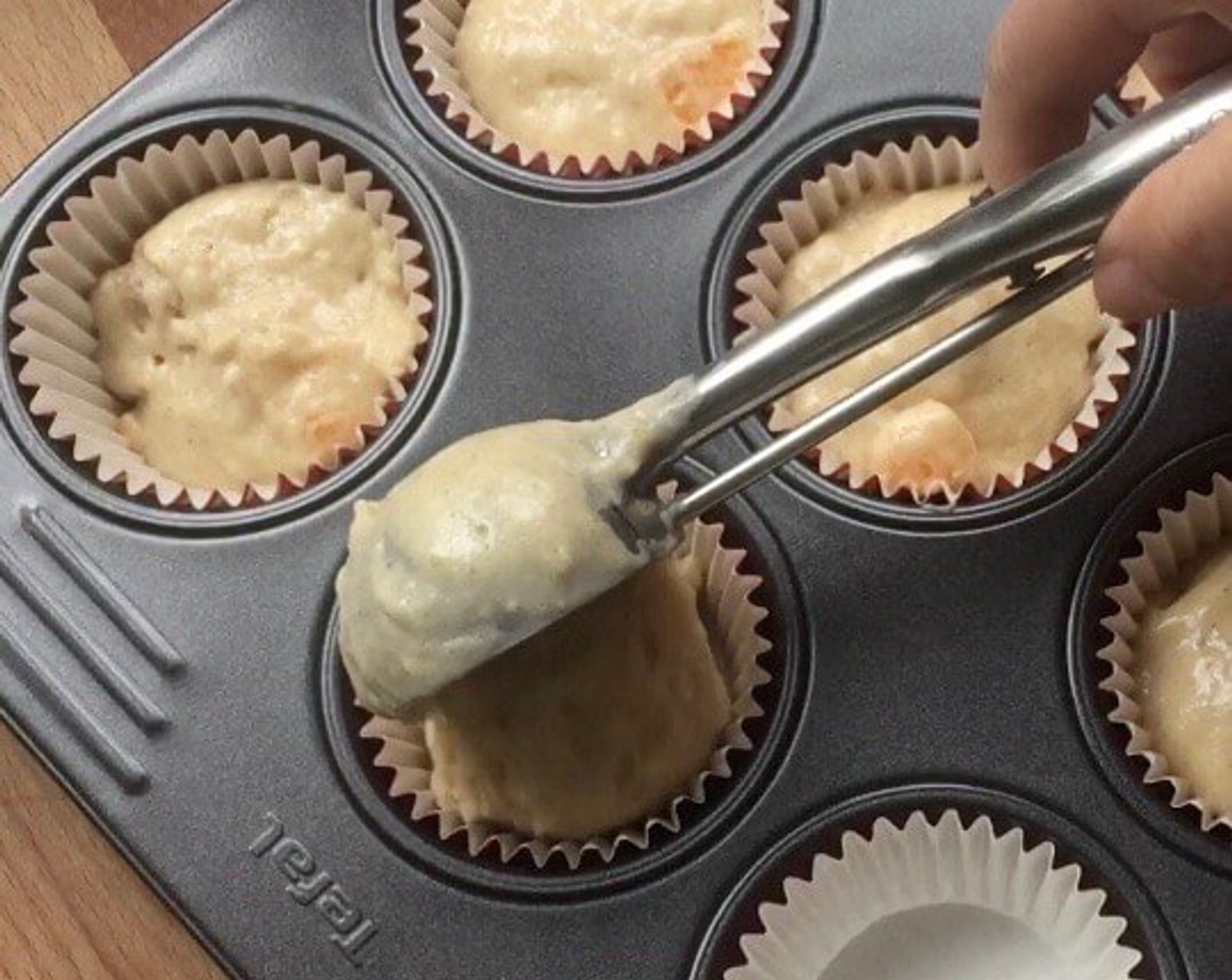 step 8 Using an ice-cream scoop, spoon the batter evenly into the muffin cups till 3/4 full.