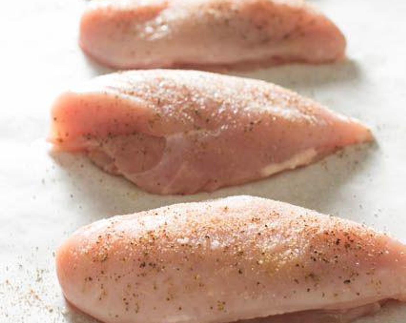 step 4 Place the chicken breast halves on a baking sheet lined with parchment paper. Season with Salt (to taste), Ground Black Pepper (to taste), and a dash of garlic powder.