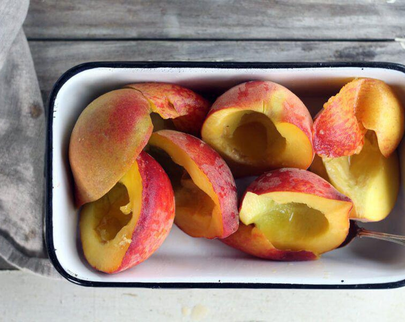 step 2 Wash Peaches (4) and dry them. Cut each peach in half and remove the peach pits.