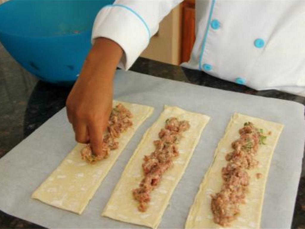 Step 4 of Sausage Bites With Maple Lemon Sauce Recipe: Take a small amount of the sausage mix and place down the center of puff pastry strips.