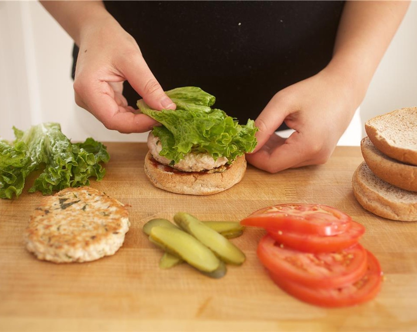 step 11 Spread one tablespoon of Ketchup (1/3 cup) and Dijon Mustard (2 Tbsp) on each bottom bun. Add the turkey patties and top each with an Escarole Lettuce (2 pieces) leaf, tomatoes, and Dill Pickles (2). Place the top bun on the burger.