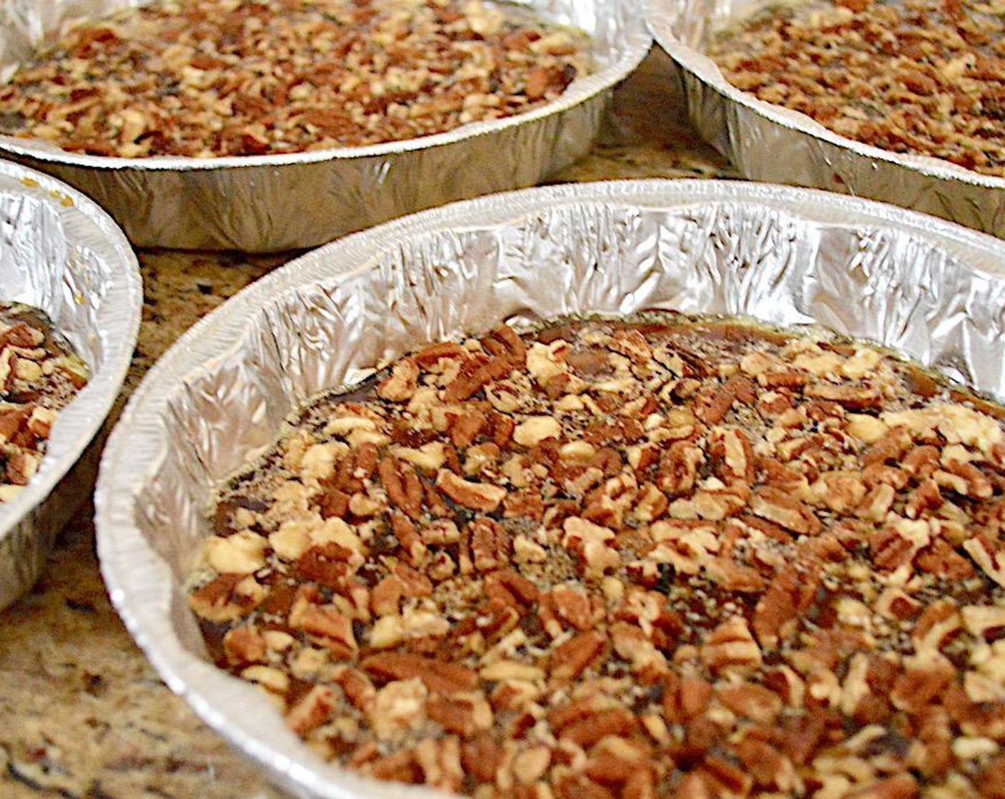 step 7 Divide the glaze evenly among them, making sure it is an even layer across the whole bottom. Sprinkle Chopped Pecans (2 cups) into an even layer in each pan and press them lightly into the glaze. Set the pans aside.
