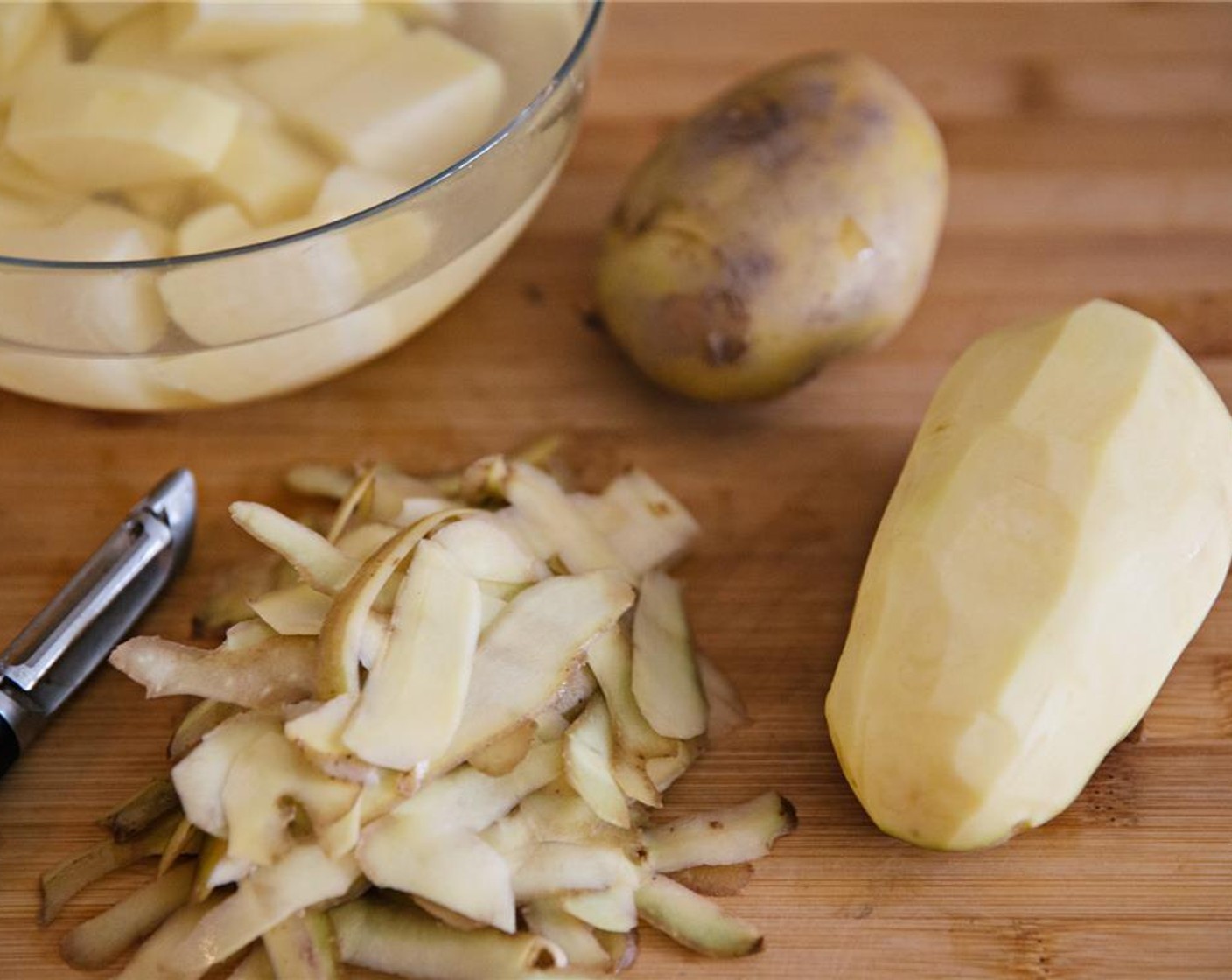 step 1 Wash and peel Potatoes (4) and cut into quarters. Place in a bowl of water and leave to soak for 20 minutes.