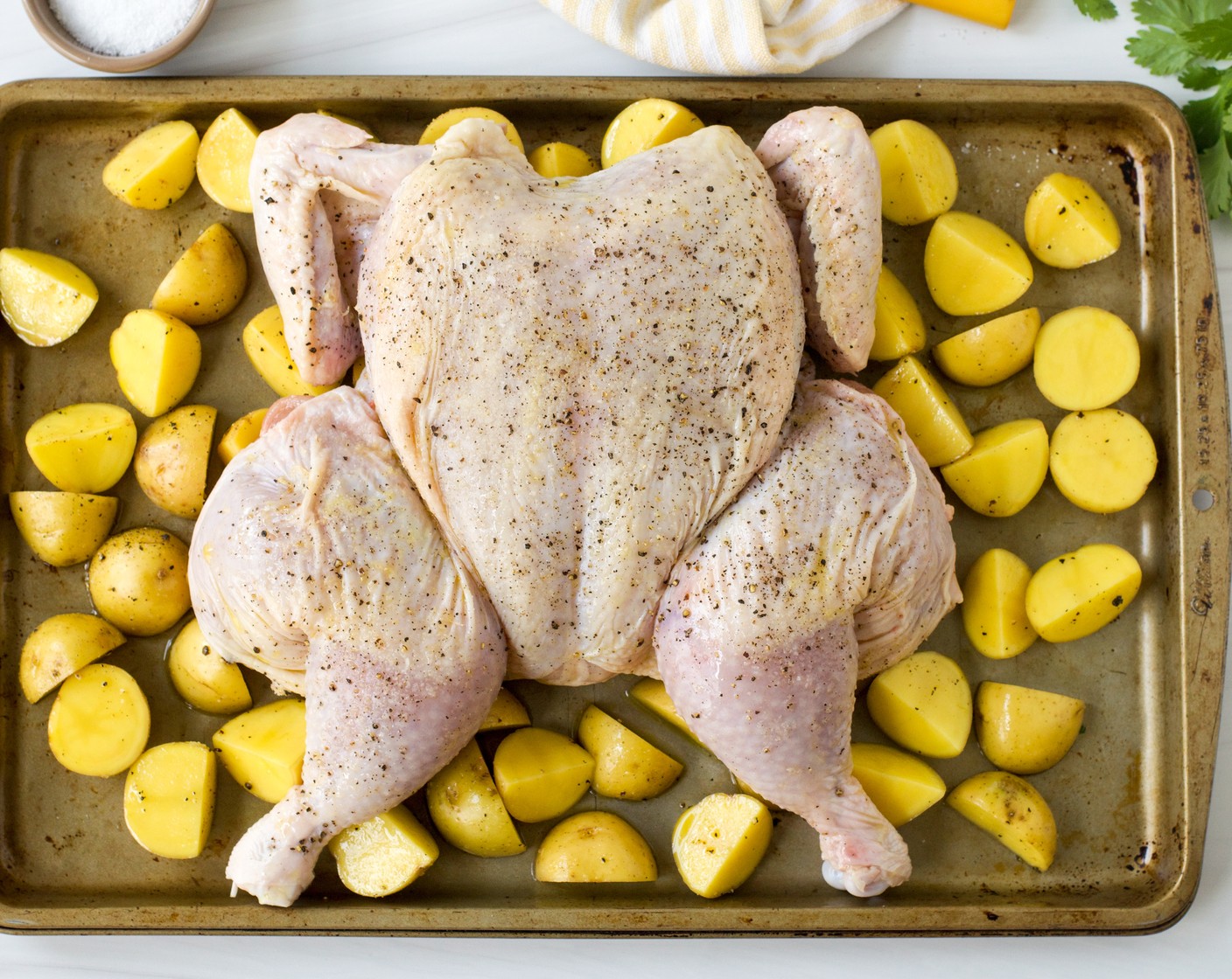 step 4 Place the spatchcocked chicken on top of the potatoes and rub the outside with the remaining Extra-Virgin Olive Oil (2 Tbsp) and season it with the remaining Kosher Salt (1 tsp) and Freshly Ground Black Pepper (1/2 tsp). Place the sheet pan in the oven and roast until the internal temperature of the chicken reaches 160 degrees F (71 degrees C), 40 to 45 minutes, rotating the pan halfway through.