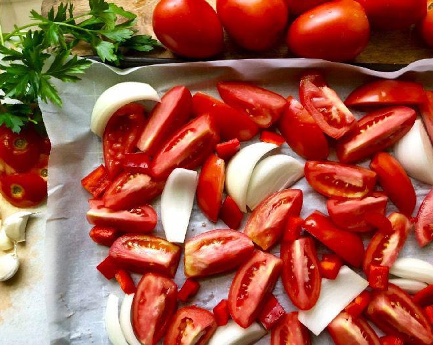 step 2 Arrange the Plum Tomatoes (3 lb), Onion (1), cut lengthwise into 8 wedges, and Red Bell Pepper (1/2 cup) in a single layer on the lined baking pans.