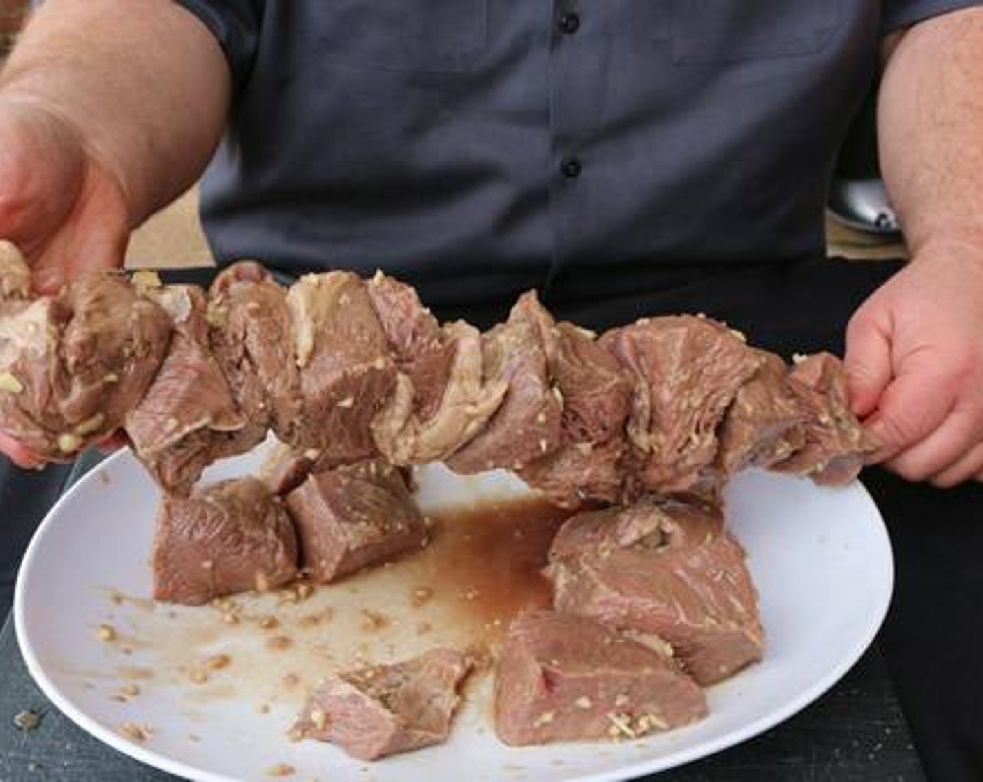step 4 Remove meat from marinade and allow excess liquid to drain. Skewer each piece of sirloin onto rotisserie rod.