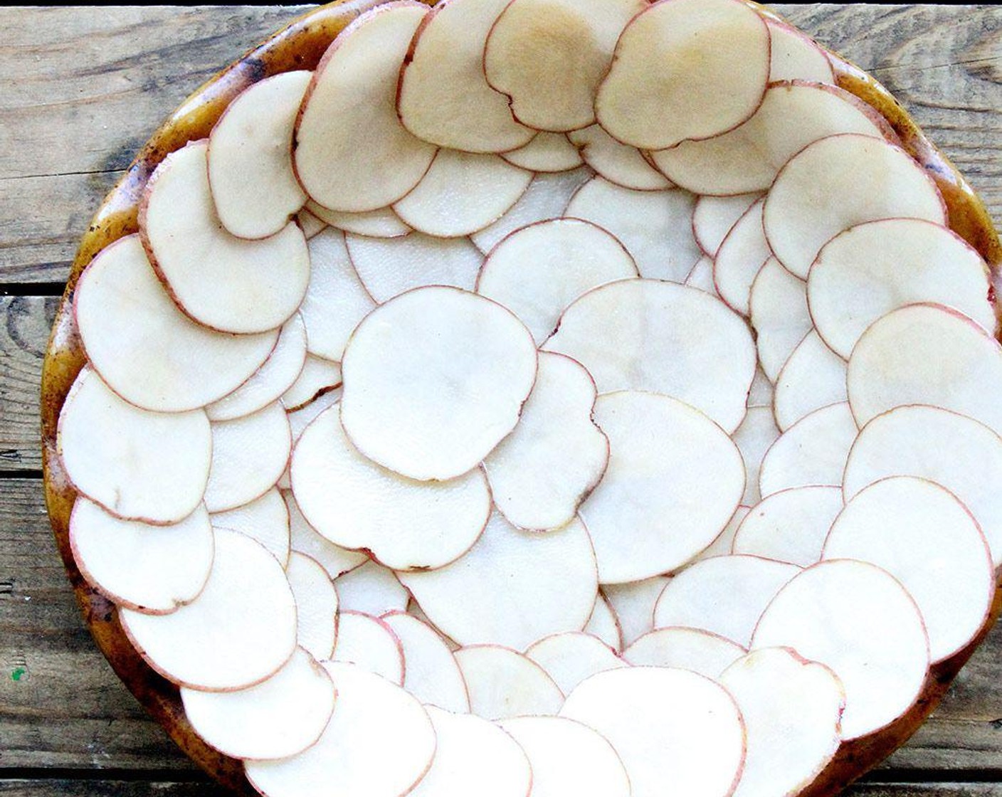 step 4 Line the quiche pan with the potatoes, overlapping them as you arrange them. Be sure the layer of potatoes closest to the edge extends above the rim.