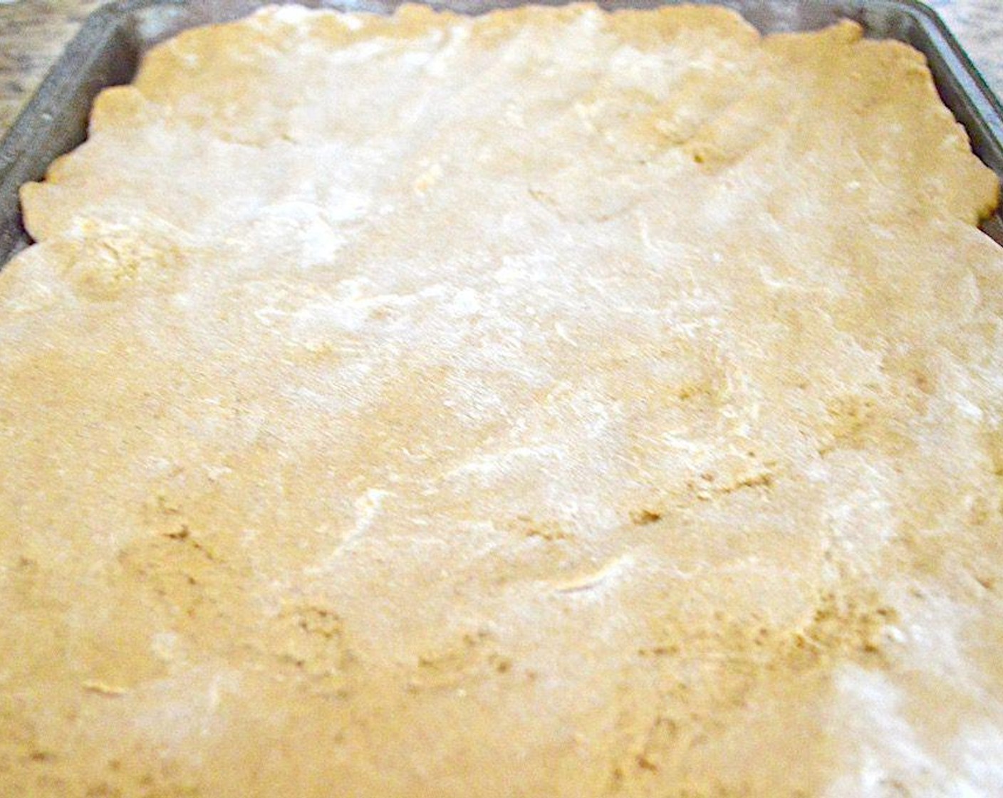 step 4 Line a sheet tray with a silicone mat and turn the dough out onto it. Flour the top of it with a generous sprinkle and also flour your hands. Use your hands to gently spread the dough out to be about 1/2 inch thick and pretty much fill the sheet tray.