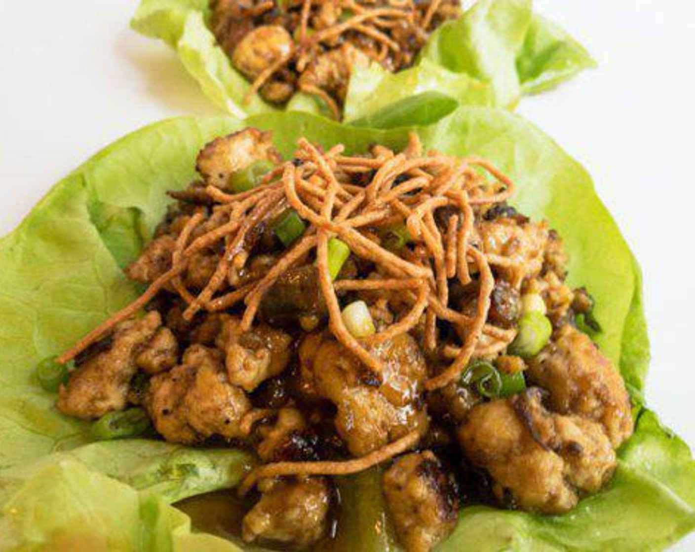 step 7 Spoon tofu mixture into lettuce leaves and top with more scallions and crispy Rice Noodles (1 cup). Pour extra sauce on top for more peanut flavor, enjoy!