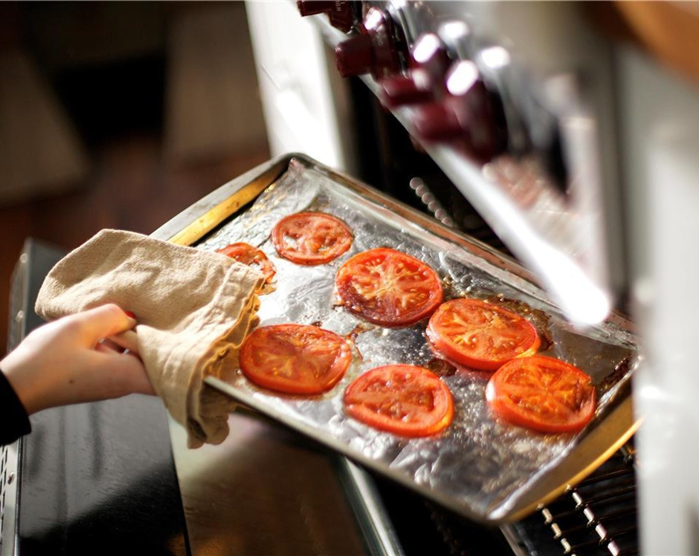 step 7 Place tomatoes in the oven, and roast for fifteen minutes. When putting the tomatoes in the oven, rotate the pan with the potatoes.