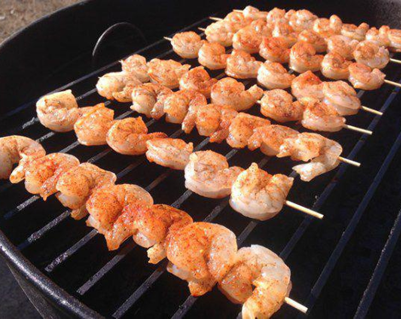 step 4 Place each skewer on the grill and give it a minute. Brush on the BBQ Shrimp sauce and flip the skewers over after 3 minutes. Hit the backside with baste and time another 3-4 minutes. The shrimp are done when they turn pink and you no longer see a transparent color.