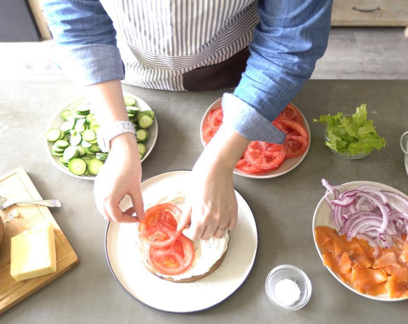 step 4 Begin assembling the layers by spreading with part of the Feta and Herb Spread (1 cup) placing the  thinly sliced Tomato (1) on top.