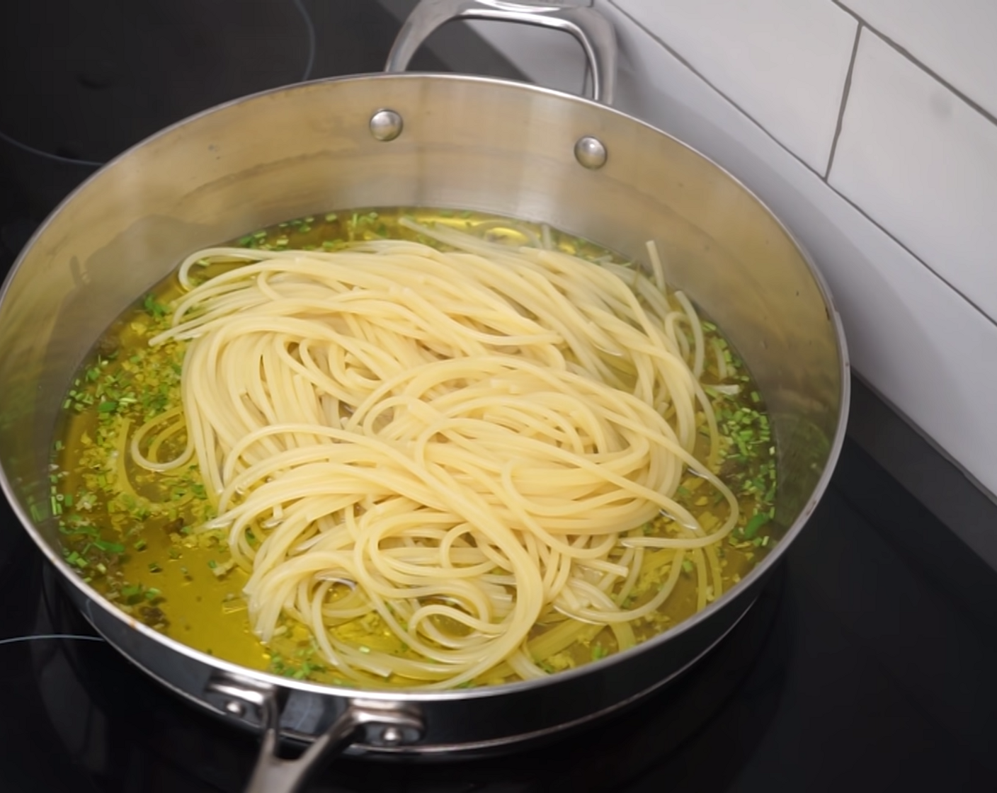 step 6 Keep an eye on the pasta cooking, and cook it between 30 seconds to 1 minute less than the packet instructions, before straining and adding it to the pan. You can use a set of long tongs to do this, adding a small amount of pasta water as you transfer the spaghetti.