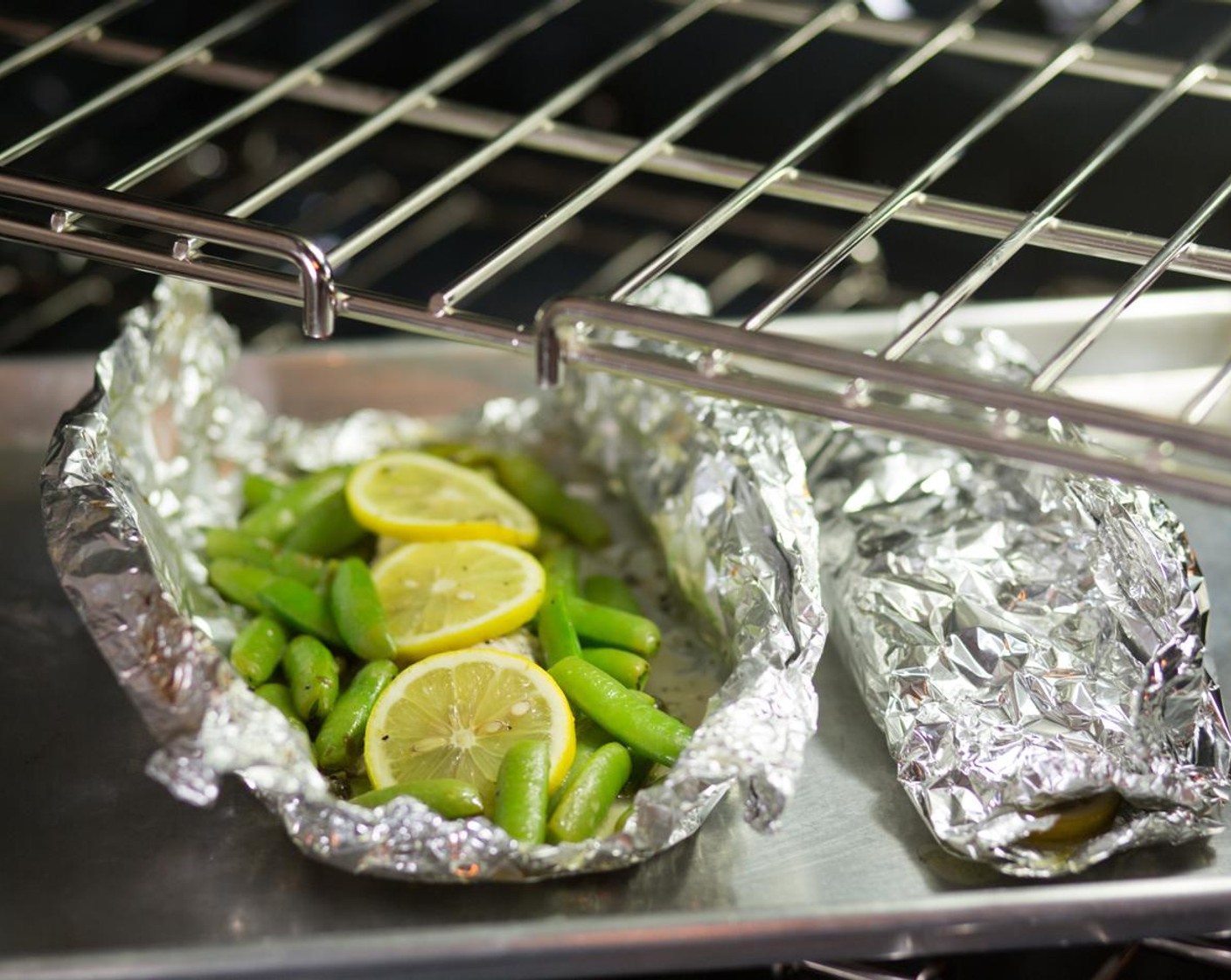 step 10 Fold and crimp the edges of the foil to make a tightly sealed packet. Place the packets on a sheet pan and place in the oven for 8 to 10 minutes.