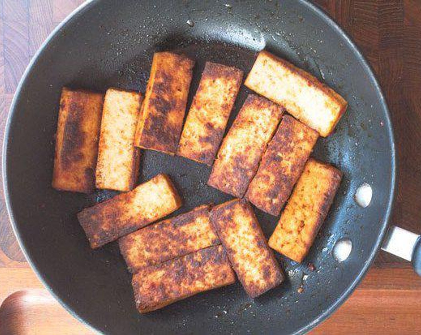 step 2 Slice the Firm Tofu (1 pckg) piece into 6 long slices. Add a little Oil (as needed) to the pan and cook each side of tofu for about 2 to 3 minutes.