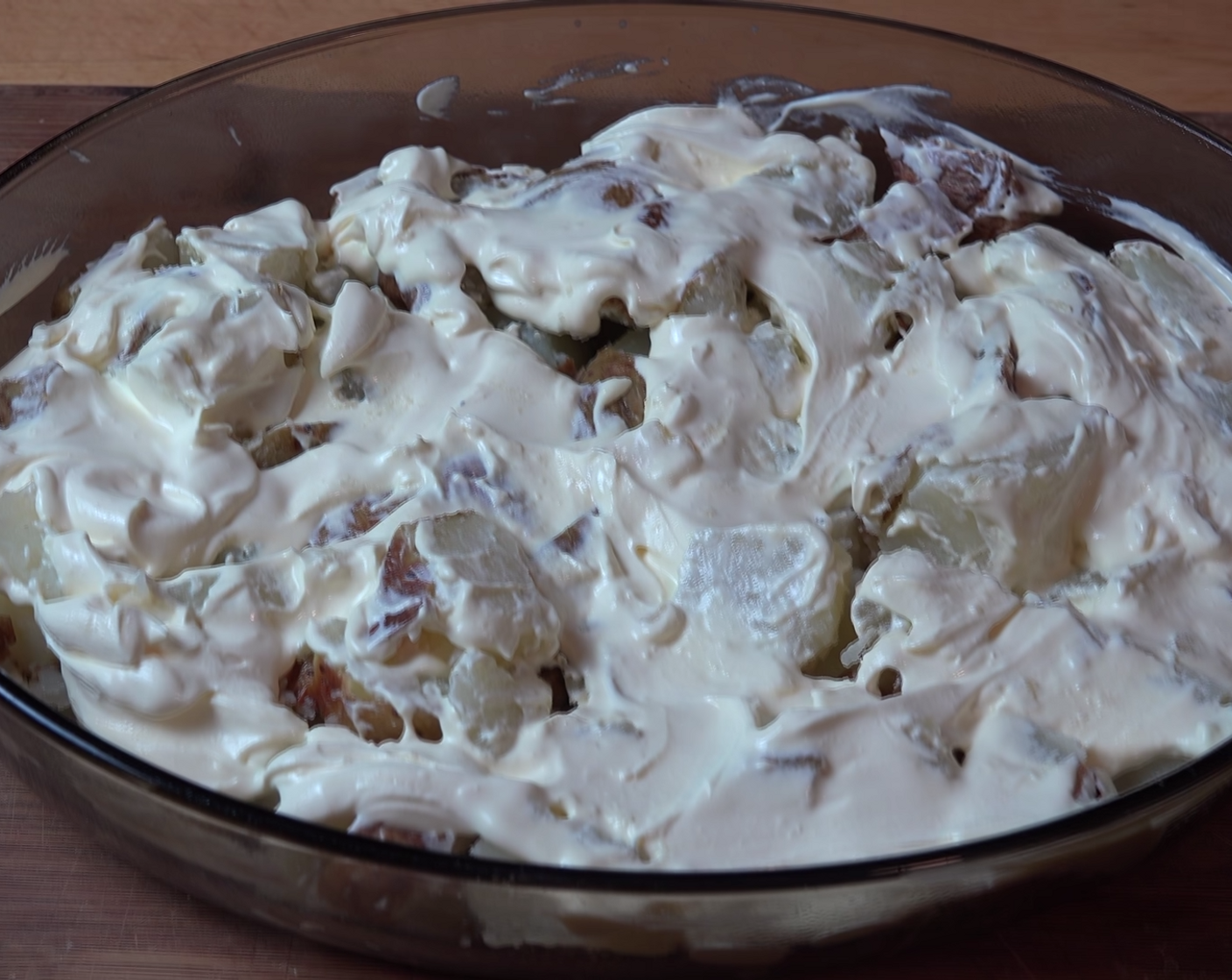 step 9 Assemble your Baked Potato Casserole. Lightly grease a large oven-proof baking dish with Nonstick Cooking Spray (as needed). Lay in 1/2 of the chopped-up potatoes, dollop over, and spread Sour Cream (1 1/4 cups).